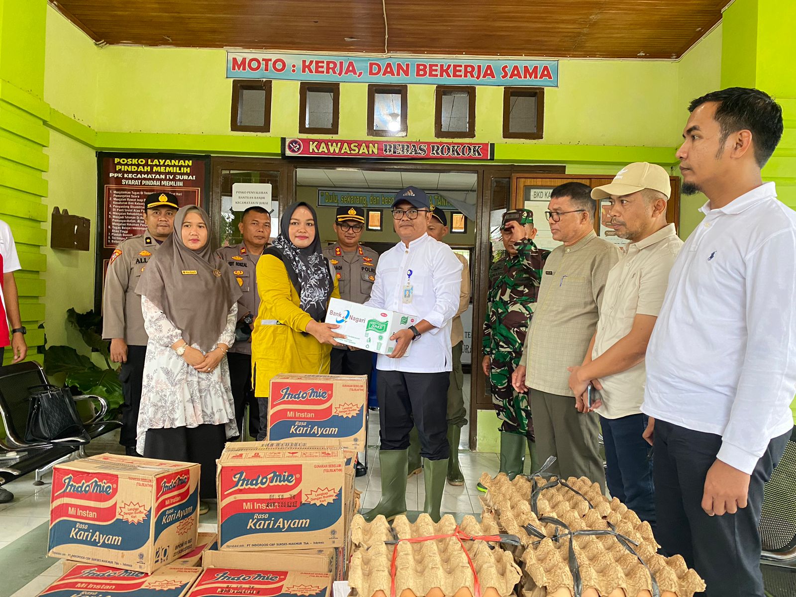 Pemimpin Cabang Bank Nagari Painan Helfiyanrika saat menyerahkan bantuan bagi korban banjir di IV Jurai